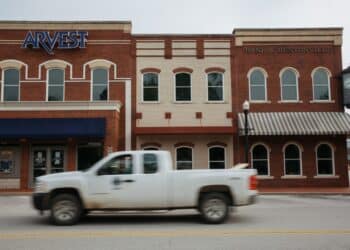 A pickup truck drives past an Arvest Bank branch on the square in Bentonville, Arkansas, U.S., on Thursday, May 28, 2020. The annual Walmart Inc. shareholder celebration attracts a varied crowd who pour money into the hotels, bars and restaurants in and around the retailer's hometown of Bentonville, Arkansas. The Covid-19 pandemic forced Walmart to pivot to a virtual gathering on June 3.