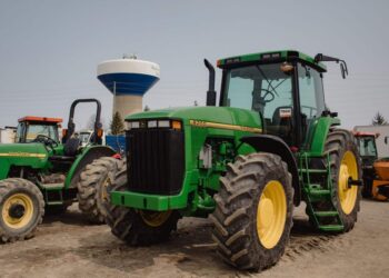 John Deere tractors in a lot during a Ritchie Bros heavy equipment auction in Bolton, Ontario, Canada, on Tuesday, May 9, 2023. Ritchie Bros Auctioneers Inc., a Canadian firm that sells heavy equipment at auctions around North America, struck an agreement in November to buy IAA, which sells damaged and written-off vehicles.