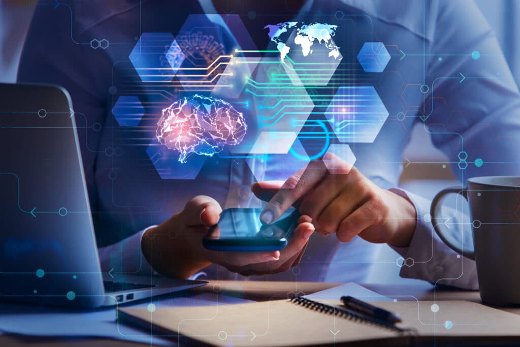 Close up of businesswoman hands using smartphone and office desk with laptop, coffee cup, notepad and abstract brain interface hologram. artificial intelligence and technology concept. double exposure
