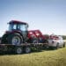 Texas farming: delivering/towing a large red tractor.