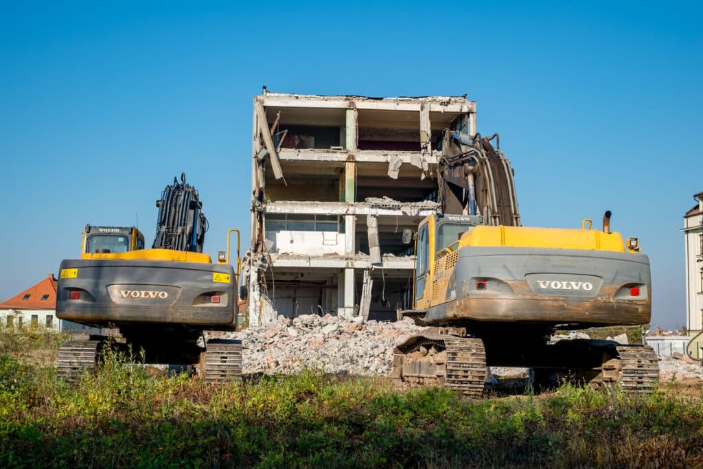 building under demolition with Volvo hydraulic excavator