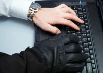 Hacker and businessman in one person working on a laptop computer