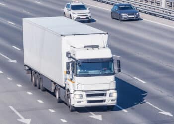 Freight truck moves on the road at sunny day time.