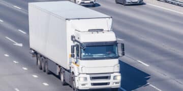 Freight truck moves on the road at sunny day time.
