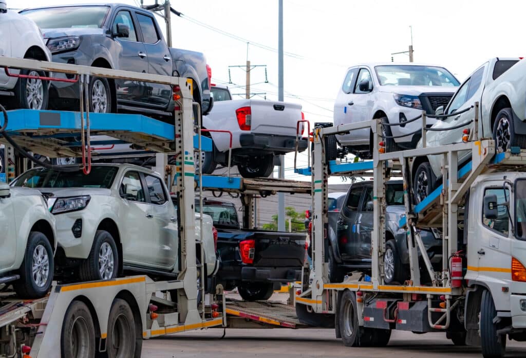 Car carrier trailer transport new car from manufacturing factory to dealer. auto vehicle haul truck delivery. transport logistics in automotive industry. car carrier trailer load new car to shipping.