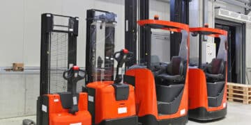 Four red forklift trucks in distribution warehouse