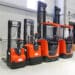 Four red forklift trucks in distribution warehouse