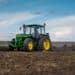 Baykivtsi, ternopil region, ukraine - april 20, 2021: a tractor 90s john deere 2850 with a homemade plow prepares the field for sowing