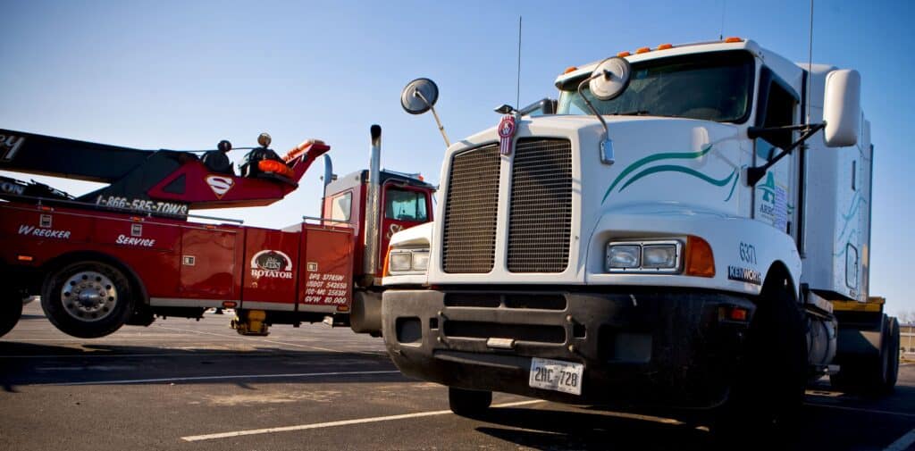 A tow truck sits next to an Arrow Trucking Co. tractor at the company's headquarters in Tulsa, Oklahoma, U.S., on Monday, Jan. 4, 2010. Arrow Trucking Co., the 61-year-old Tulsa-based flatbed carrier, suspended operations on Dec. 22, 2009, laying off employees and stranding scores of drivers by cancelling fuel credit cards, Tulsa World reported. Federal Authorities later issued an emergency order to executives to retrieve company trucks and trailers from truck stops and parking areas around the country.