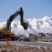 A worker uses a Volvo AB excavator to build a road during construction in Saratoga Springs, Utah, U.S., on Tuesday, March 12, 2019. The National Association of Home Builders (NAHB) released housing market index figures on March 18.