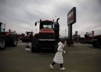 An attendee passes in front of a CNH Industrial NV Case IH Agriculture brand Steiger Quadtrac 540 tractor displayed during the World Agriculture Expo in Tulare, California, U.S., on Tuesday, Feb. 12, 2019. The annual World AG Expo has more than 1,500 exhibitors displaying the latest in farm equipment, communications and technology on 2.6 million square feet of exhibit space.