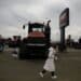 An attendee passes in front of a CNH Industrial NV Case IH Agriculture brand Steiger Quadtrac 540 tractor displayed during the World Agriculture Expo in Tulare, California, U.S., on Tuesday, Feb. 12, 2019. The annual World AG Expo has more than 1,500 exhibitors displaying the latest in farm equipment, communications and technology on 2.6 million square feet of exhibit space.
