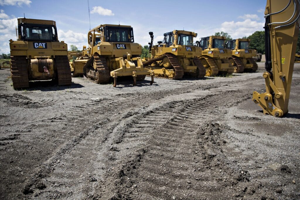Track marks scar the ground near a row of Caterpillar Inc. equipment at the Altorfer Cat dealership in East Peoria, Illinois, U.S., on Tuesday, July 21, 2015. Caterpillar Inc. is scheduled to report quarterly earnings on July 23.