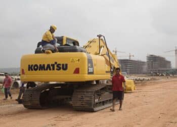 A worker squats on a Komatsu Ltd. excavator near the construction site for the Otres 2 development in Sihanoukville, Cambodia, on Saturday, March 31, 2018. It's against the law for Cambodians to gamble. Yet in Sihanoukville, a once-sleepy resort town where three dozen casinos have sprung up, most in the past two years, Cambodians are betting that an infusion of Chinese-built infrastructure will pay off with jobs and prosperity
