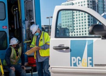 Pacific Gas & Electric Corp. (PG&E) workers wearing protective masks look at clipboard in San Francisco, California, U.S., on Wednesday, Feb. 24, 2021. PG&E Corp. is scheduled to release earnings figures on February 25.