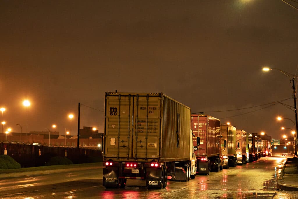 Tractor-trailer trucks wait to enter the Port of Baltimore in Baltimore, Maryland, U.S., on Monday, March 23, 2020. A shipping container shortage that's left everything from Thai curry to Canadian peas idling in ports may be about to get a whole lot worse as China steps up its coronavirus precautions on incoming vessels.