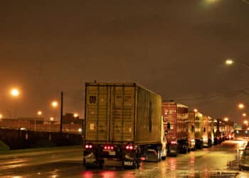 Tractor-trailer trucks wait to enter the Port of Baltimore in Baltimore, Maryland, U.S., on Monday, March 23, 2020. A shipping container shortage that's left everything from Thai curry to Canadian peas idling in ports may be about to get a whole lot worse as China steps up its coronavirus precautions on incoming vessels.