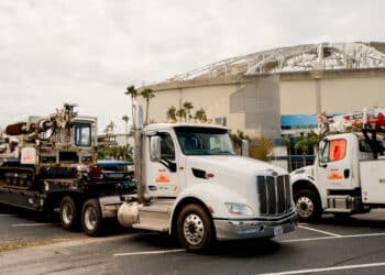 A truck pulls construction equipment in front of Tropicana Field after Hurricane Milton in St. Petersburg, Florida, US, on Friday, Oct. 11, 2024. Hurricane Miltons devastating path across Florida has left at least 10 dead, millions without power, and destroyed homes and crops, as authorities warn it could take days to assess the full extent of the damages.