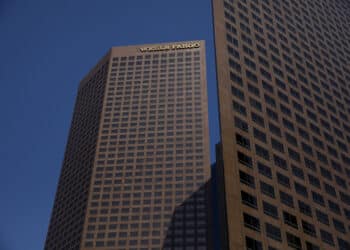Wells Fargo & Co. signage is displayed on the Wells Fargo Center skyscraper in Los Angeles, California, U.S., on Thursday, April 19, 2018. Wells Fargo & Co.'s financial ties to gunmakers and the National Rifle Association have prompted the American Federation of Teachers to remove the bank from its list of recommended mortgage lenders.