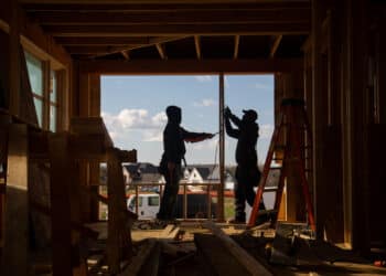 Construction workers install frames for windows and doors in a home being built in Bloomfield Hills, Michigan.
