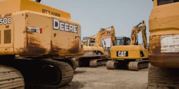 Excavators in a lot during a Ritchie Bros heavy equipment auction in Bolton, Ontario, Canada, on Tuesday, May 9, 2023. Ritchie Bros Auctioneers Inc., a Canadian firm that sells heavy equipment at auctions around North America, struck an agreement in November to buy IAA, which sells damaged and written-off vehicles. RB Global