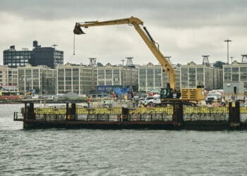 A crane sits on a pier in the IndUS,try City neighborhood of Brooklyn, New York, US, on Thursday, July 17, 2025. The crew of an American-flagged barge will lay cable to connect the Empire Wind farm to New York Citys grid  a milestone for an embattled sector.