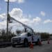 A utility truck repairs power lines following Hurricane Ian in Matlacha, Florida, US, on Wednesday, Oct. 5, 2022. President Biden and Governor DeSantis have feuded over political issues, including migrants, but are coordinating on assistance for Floridians hit by a hurricane Biden's called "among the worst in the nation's history."