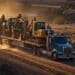 a photo of a truck hauling construction equipment