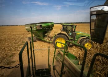A tractor towing a hopper approaches a combine to begin receiving cut corn. Corn harvest at the 8000 acre Triple Run Farm in Dockery, Mississippi, US, on Thursday, Aug. 14, 2025. Chicago corn futures fell to the lowest level in nearly a year after the US Department of Agriculture raised its already record-large outlook for the American harvest.
