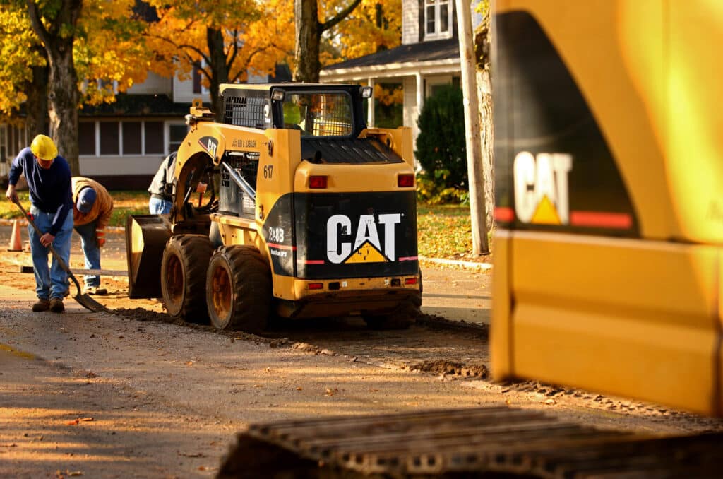 A Caterpillar Inc. 248B skid steer loader aids contractors during road work in Topeka, Indiana, U.S., on Monday, Oct. 24, 2011. Caterpillar Inc., the world's largest construction and mining-equipment maker, posted third-quarter profit and sales that topped analysts' estimates as demand rose for shovels and drills used to dig up metals.