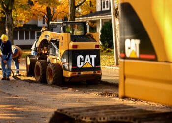 A Caterpillar Inc. 248B skid steer loader aids contractors during road work in Topeka, Indiana, U.S., on Monday, Oct. 24, 2011. Caterpillar Inc., the world's largest construction and mining-equipment maker, posted third-quarter profit and sales that topped analysts' estimates as demand rose for shovels and drills used to dig up metals.