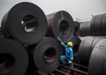A worker inspects coils of steel in the storage yard at a steel plant in Ostrava, Czech Republic.