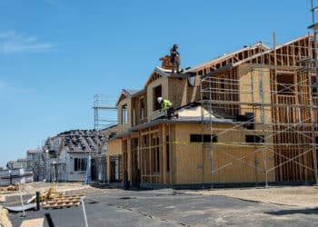 Workers install roofing on a home under construction in Vacaville, California.