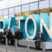 Attendees sit beside a Traton logo outside the Volkswagen AG (VW) exhibition area at the IAA Commercial Vehicles Show in Hanover, Germany, on Wednesday, Sept. 19, 2018. Volkswagen AG's truck unit is pushing to reduce its dependence on its main European market and lift profit margins in a challenge to commercial-vehicle industry leaders Daimler AG and Volvo AB.