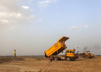 Workers observe a bulldozer and a dump truck excavate sand and rocks from an open pit mine at the Sindh Engro Coal Mining Co. site in the Thar desert, Pakistan, on Wednesday, March 8, 2017. In the dusty scrub of the Thar desert, Pakistan has begun to dig up one of the world's largest deposits of low-grade, brown, dirty coal to fuel new power stations that could revolutionize the country's economy. The project is one of the most expensive among an array of ambitious energy developments that China is helping the country to build as part of a $55 billion economic partnership.