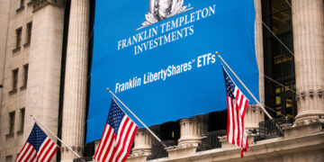 American flags fly in front of Franklin Resources Inc. signage displayed outside the New York Stock Exchange (NYSE) in New York, U.S., on Monday, Nov. 6, 2017. Stocks rose and bonds advanced, while the euro and dollar slipped as President Donald Trump tried to tackle trade on his Asia tour.
